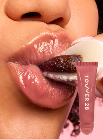 [A close up of a model wearing Tower 28 Beauty's LipSoftie™ Lip Treatment in Red Bean Mochi on her lips]