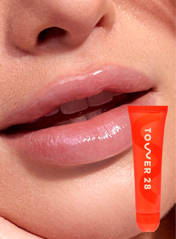[A close up of a model wearing Tower 28 Beauty's LipSoftie™ Lip Treatment in SOS Vanilla on her lips]