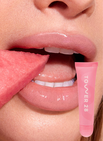 [A close up of a model wearing Tower 28 Beauty's LipSoftie™ Lip Treatment in Watermelon Kiwi on her lips]