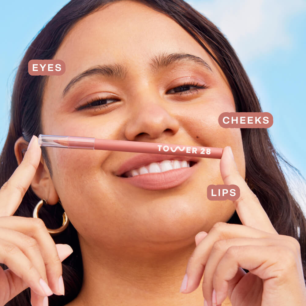 A person wearing the Tower 28 Beauty OneLiner in the shade Check Me Out on her lips, cheeks, and eyes. [Check Me Out]